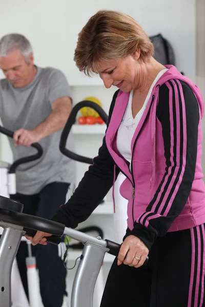 Older woman using a treadmill — Stock Photo, Image