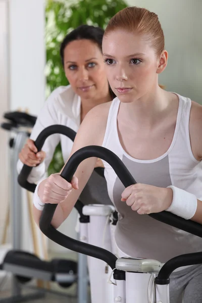 Mulheres usando máquinas de musculação no ginásio — Fotografia de Stock