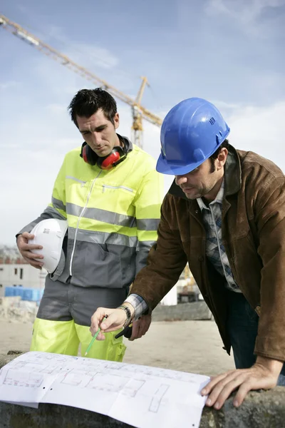 Foreman e colega examinando planos — Fotografia de Stock