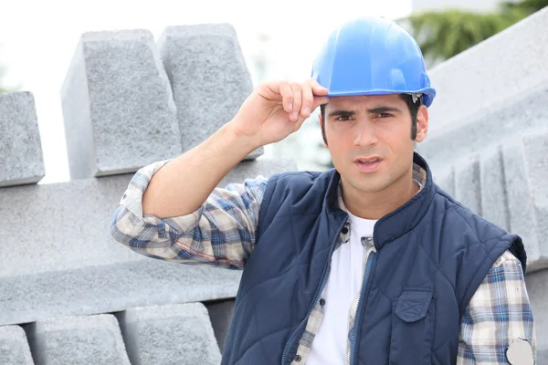 Travailleur de la construction dans un casque à côté de bordure de béton — Photo
