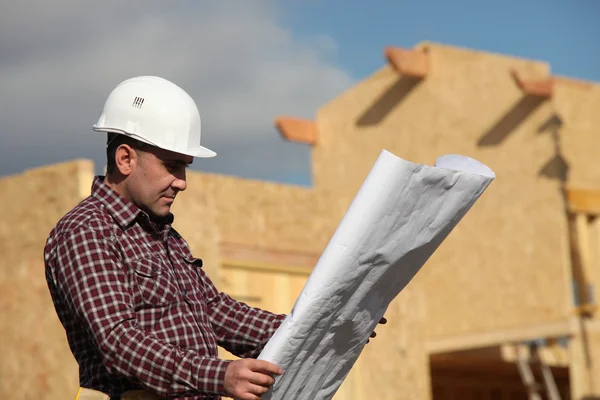 Trabalhador da construção civil a olhar para um desenho — Fotografia de Stock