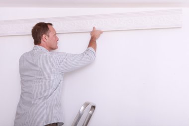 Man installing a protection on a wall clipart