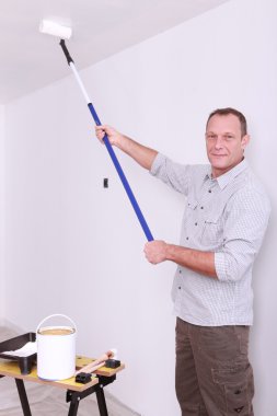 Man painting ceiling with roller clipart