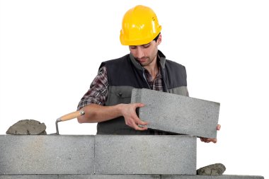 Bricklayer making a block wall clipart