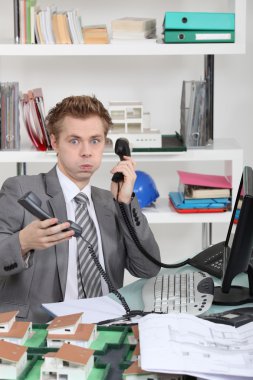 Young man overwhelmed with phone calls clipart