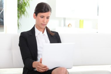 Businesswoman using laptop in office clipart