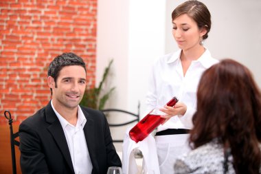 Sommelier presenting a wine to a restaurant patron clipart