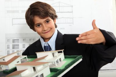 Boy dressed as a businessman in an architect's office clipart