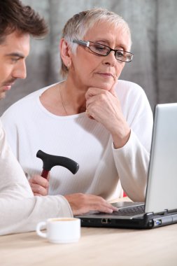 Elderly woman learning internet skills clipart