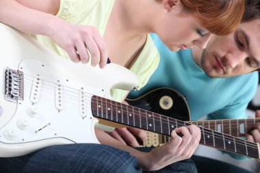 Girl learning to play guitar clipart