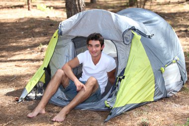 Teenage boy sat in tent clipart