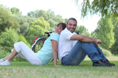 Couple relaxing in a park clipart