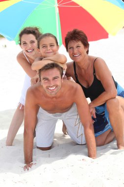 Family holidaying on a sandy beach clipart