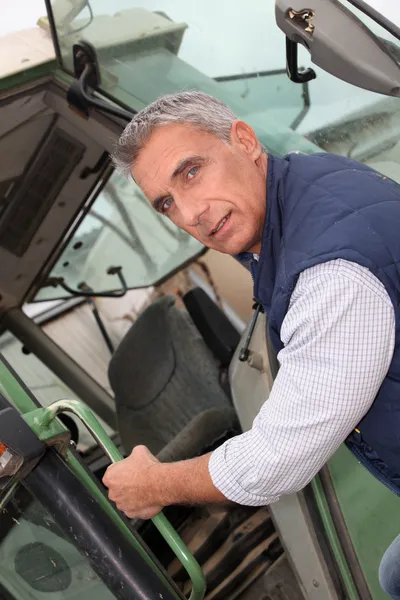 Portrait of a farmer climbing on tractor — Stock Photo, Image