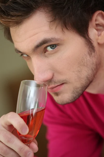 Jeune homme sentant un verre de rose — Photo