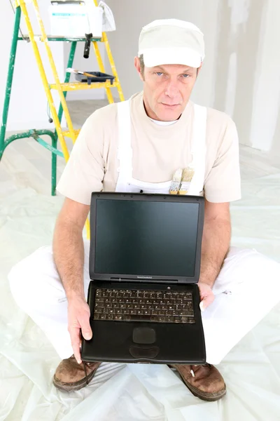Decorator holding a laptop with a blank screen — Stok fotoğraf