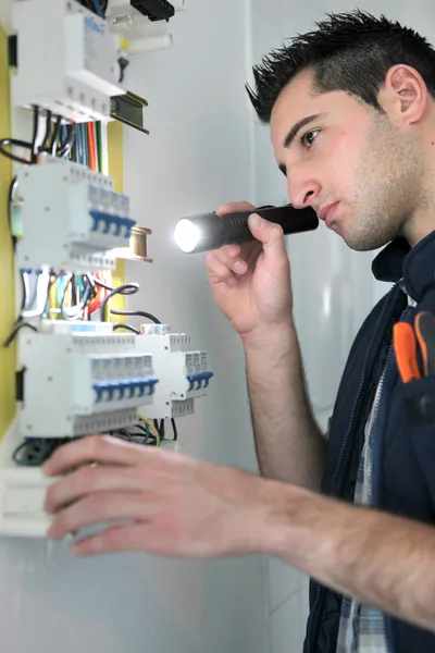 Eletricista examinando caixa de fusíveis — Fotografia de Stock