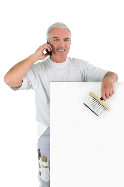 一位白发苍苍的室内设计师站用画笔和移动电话 — 图库照片