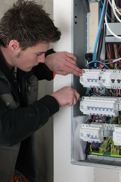 Electricista verificando un tablero de distribución — Foto de Stock