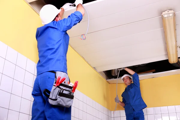 Dva elektrikář inspekce stropní panely — Stock fotografie