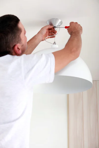 Man vaststelling plafondlamp — Stockfoto