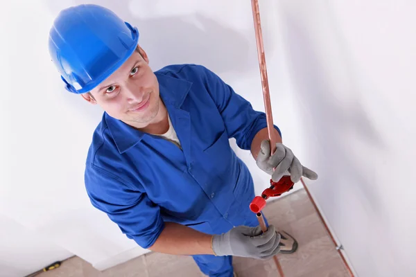 Smiling laborer installing piping — Stock Photo, Image