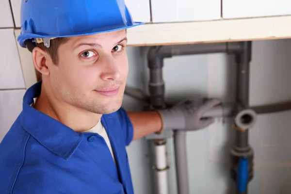 Jovem encanador masculino instalar tubos — Fotografia de Stock