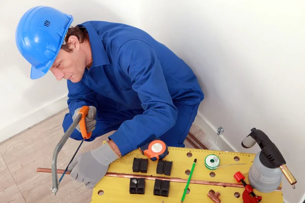 stock image Plumber cutting copper pipe