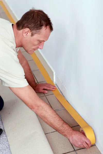 Man at home preparing to lay new flooring — Stock Photo, Image