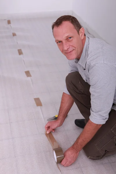Egy ember, egy új padló fektetése. — Stock Fotó