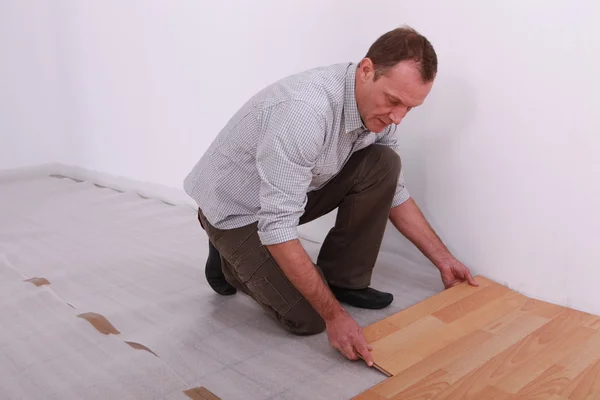 铺设实木复合地板一个男人的肖像 — 图库照片