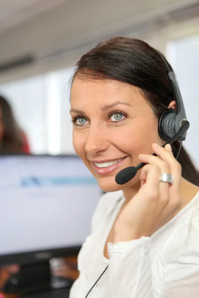 Kvinna som bär en telefon headset i ett kontor — Stockfoto