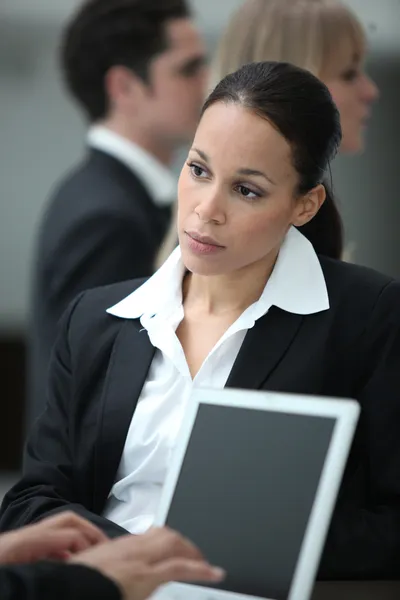 Vrouwelijke uitvoerend werken met collega op een laptop — Stockfoto