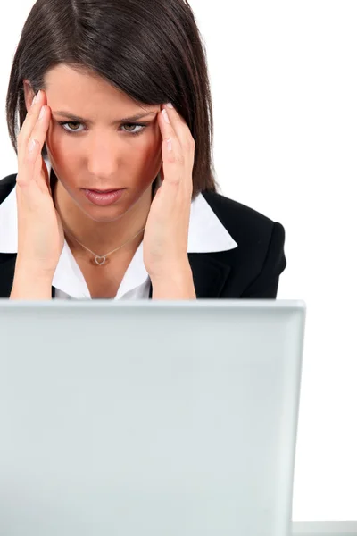 Frau bei der Arbeit mit Kopfschmerzen — Stockfoto