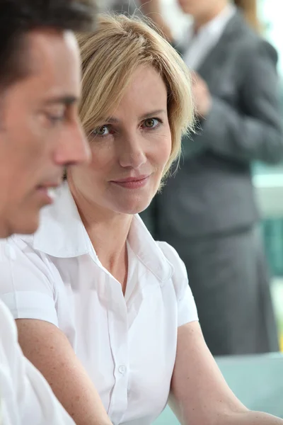 Concentre-se em uma mulher sentada com colegas — Fotografia de Stock