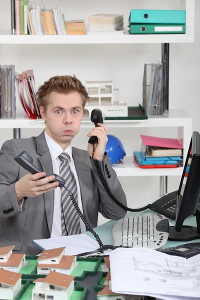 Jonge man overstelpt met telefoongesprekken — Stockfoto