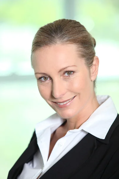 Kop en schouders van een glimlachende vrouwelijke executive — Stockfoto