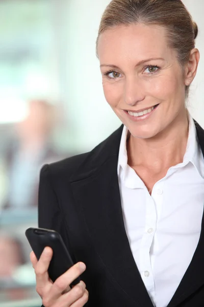 Glimlachende zakenvrouw met een office-achtergrond — Stockfoto