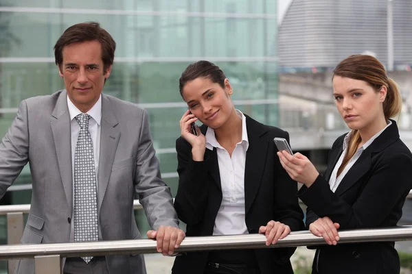 Zakenmannen en -vrouwen op de telefoon buiten. — Stockfoto