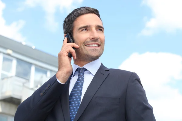 Venditore di immobili in piedi all'aperto con telefono cellulare — Foto Stock