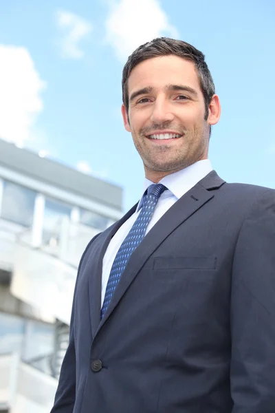 Young businessman in suit stood outside building — Stock Photo, Image