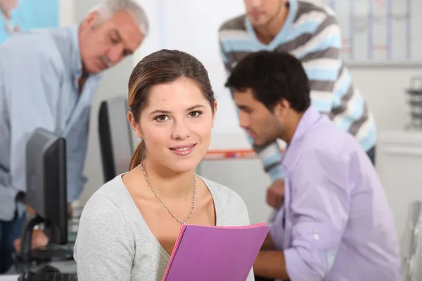 Woman surrounded by her colleagues at work — Stock Photo, Image