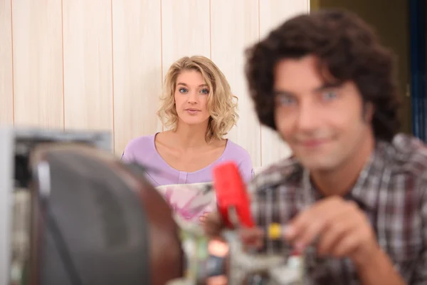Technicus reparatie computer en vrouw op achtergrond — Stockfoto