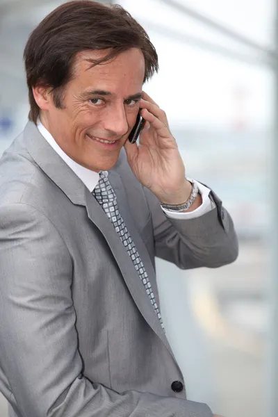 Επιχειρηματίας που είναι χαμογελώντας στο κινητό τηλέφωνο — Φωτογραφία Αρχείου