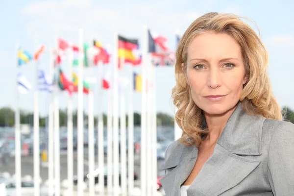 Businesswoman with flags — Stockfoto
