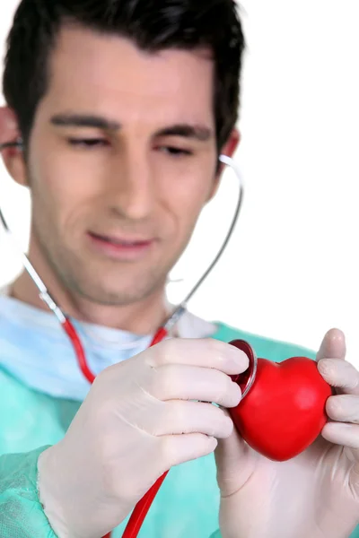 Doctor listening to the heartbeat of a heart — Stock Photo, Image