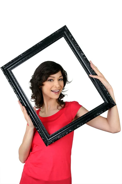Woman holding herself within a picture frame — Stock Photo, Image