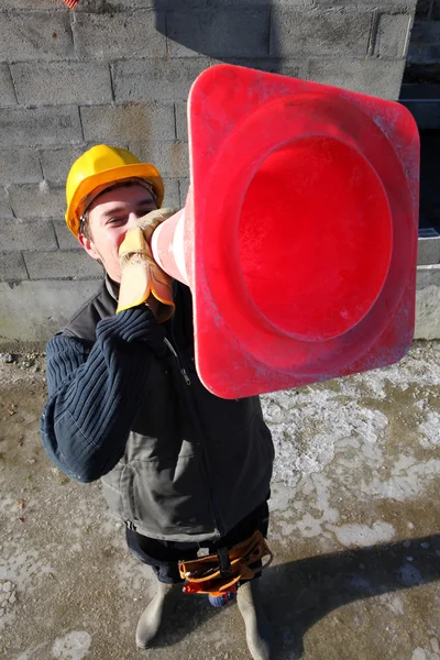Builder shouting through traffic cone — Zdjęcie stockowe