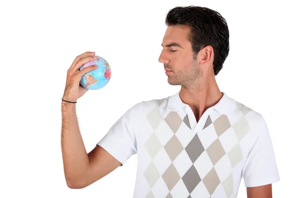 Jeune homme tenant un globe — Photo