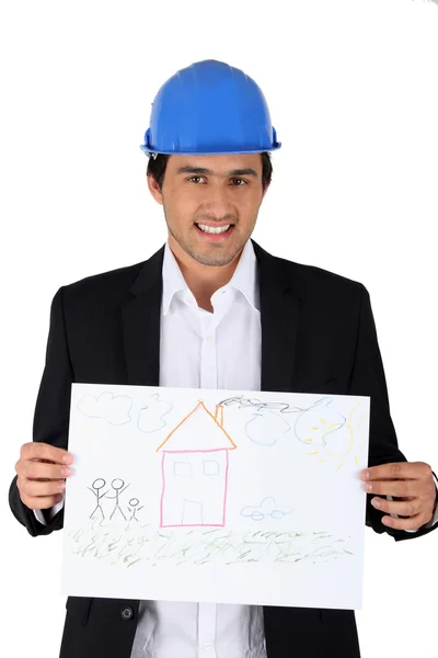 Bauunternehmer hält ein Kind im Arm, das ein Haus zeichnet — Stockfoto